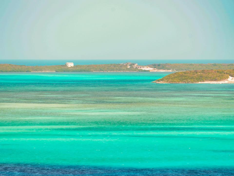 A far-off view of Bahamian islands with clear ocean waters in the foreground
