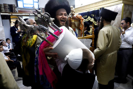 Ultra-Orthodox Jewish men dance with Torah scrolls during the celebrations of Simchat Torah in a synagogue at the Mea Shearim neighbourhood of Jerusalem October 1, 2018. REUTERS/Ronen Zvulun
