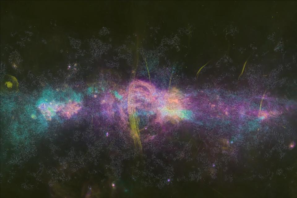 Map of the central region of the Milky Way with hot gas in pink, cool dust in blue, and radio wave emitting filaments in yellow