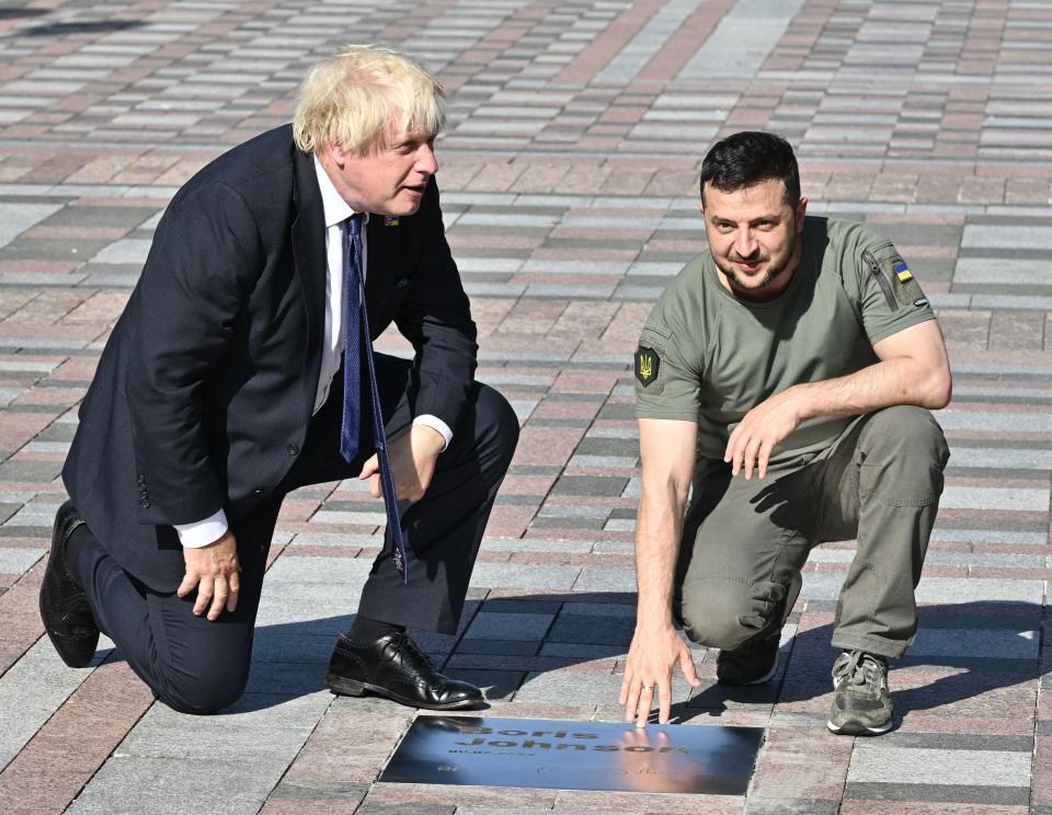 Ukrainian President Volodymyr Zelensky (R) shows British Prime Minister Boris Johnson (L) his name engraved on a plaque inaugurated at the Ally of Bravery on Ukraine's Independence Day on August 24, 2022, amid Russia's invasion of Ukraine. - British Prime Minister Boris Johnson was in Kyiv on August 24, 2022, hailing the 