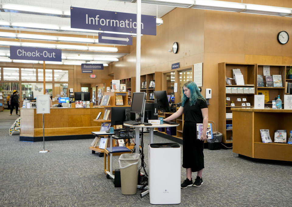 Khloe Warne, 12, uses a computer at the Josephine Community Library, Thursday, May 18, 2023, in Grants Pass, Ore. Khloe was put on shortened school days by her school district after incidents in which she fought with students and threw a desk in outbursts her mother, Alyssa, attributes to a failure to support her needs. Now she only attends school one day a week for two hours, and hasn't been on a regular school schedule for years, instead spending much of her time at her mother's bakery or at the local library. (AP Photo/Lindsey Wasson)