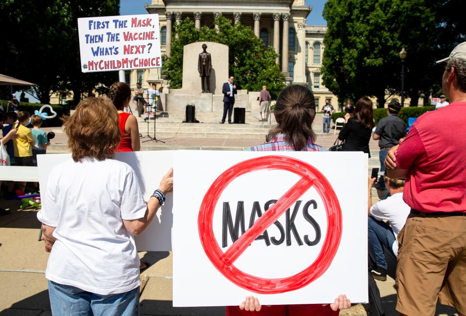 Protesters listen to William Kelly, host of the Citizen Kelly Show, as he speaks about suing Gov. JB Pritzker over COVID-19 restrictions during the "Million Unmasked March" at the Illinois State Capitol, Saturday, July 25, 2020, in Springfield, Ill. The protesters gathered in front of the Abraham Lincoln Statue to voice their opposition to guidelines that children be required to wear face masks when they return to school during the COVID-19 pandemic. (Justin L. Fowler/The State Journal-Register via AP) ORG XMIT: ILSPR103