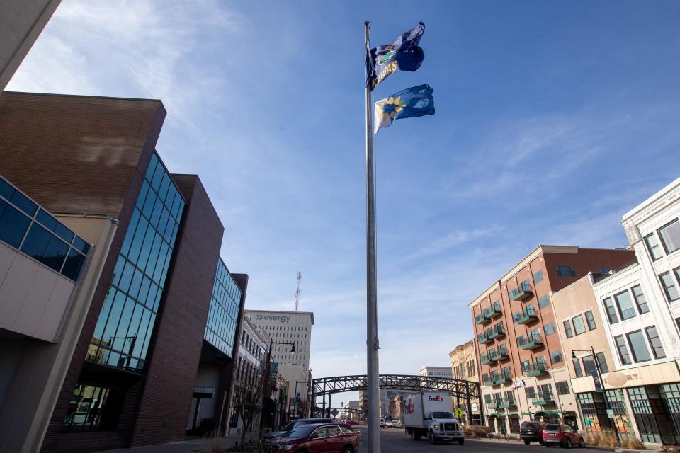 City of Topeka and Kansas flags blow in the wind in downtown Topeka. A bill in the Statehouse would authorize a specialty license plate bearing the Topeka flag.