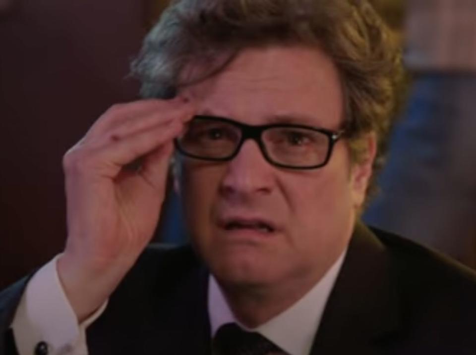 Colin Firth putting on square framed glasses.