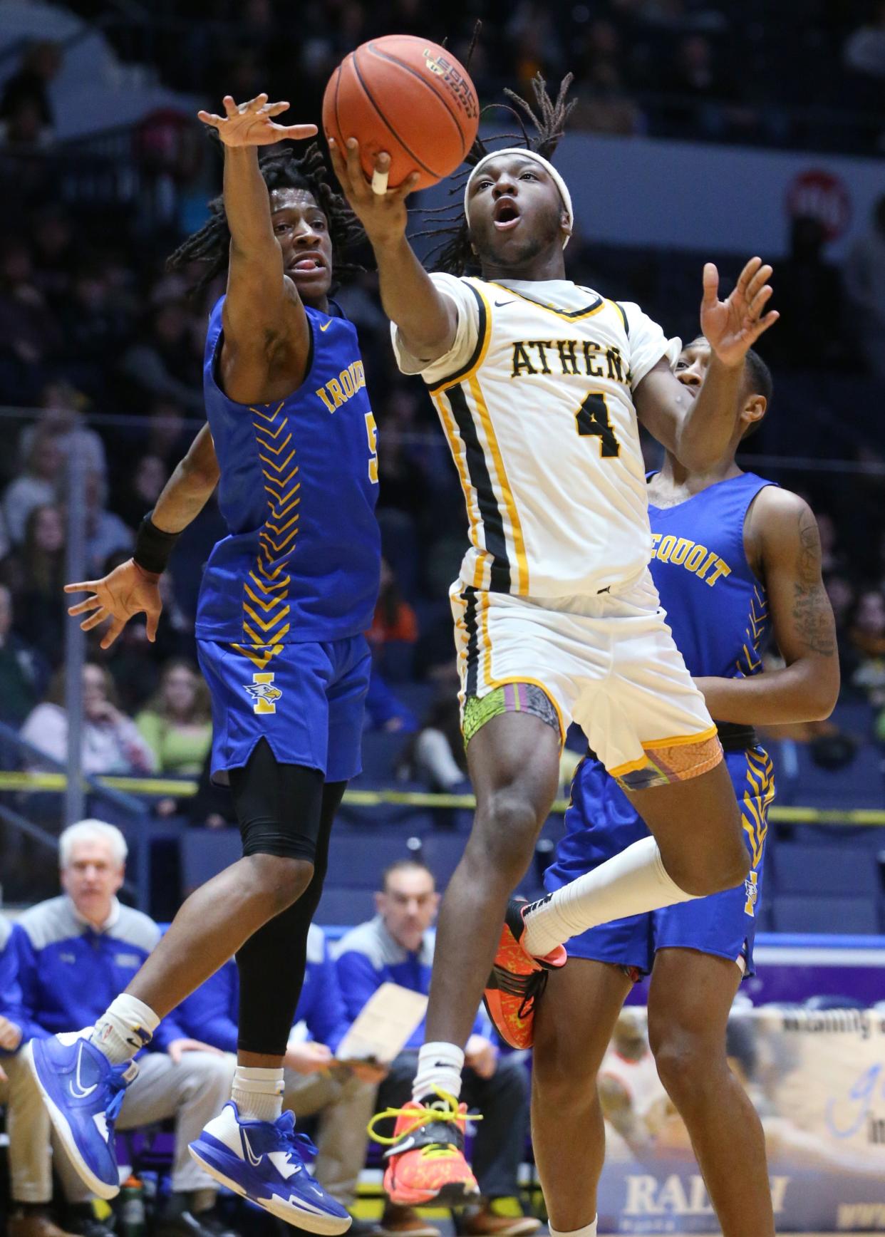 Ahtena's Zee Johnson drives to basket to score past Irondequoit's Ryan Heath during their Class A1 Championship final Saturday, March 4, 2023 a the Blue Cross Arena.