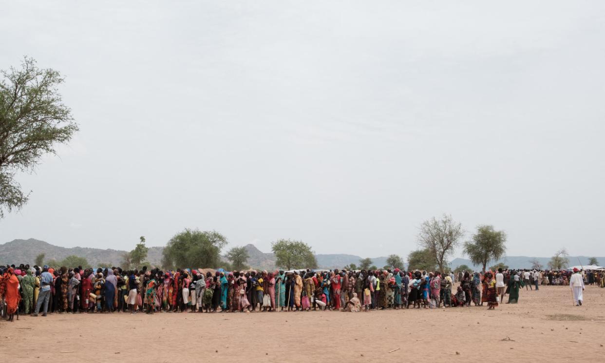 <span>People form a line for a potential food aid delivery in Agari, Sudan. More than 750,000 people face the most catastrophic form of food emergency, while 8.5 million more face acute malnutrition.</span><span>Photograph: Guy Peterson/AFP/Getty Images</span>