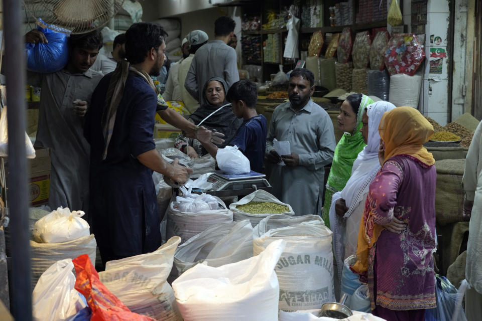 People shop at a market in Lahore, Pakistan, Wednesday, June. 12, 2024. Pakistan's new government presents its first budget today in Parliament as it seeks new long-term IMF bailout. (AP Photo/K.M. Chaudary)