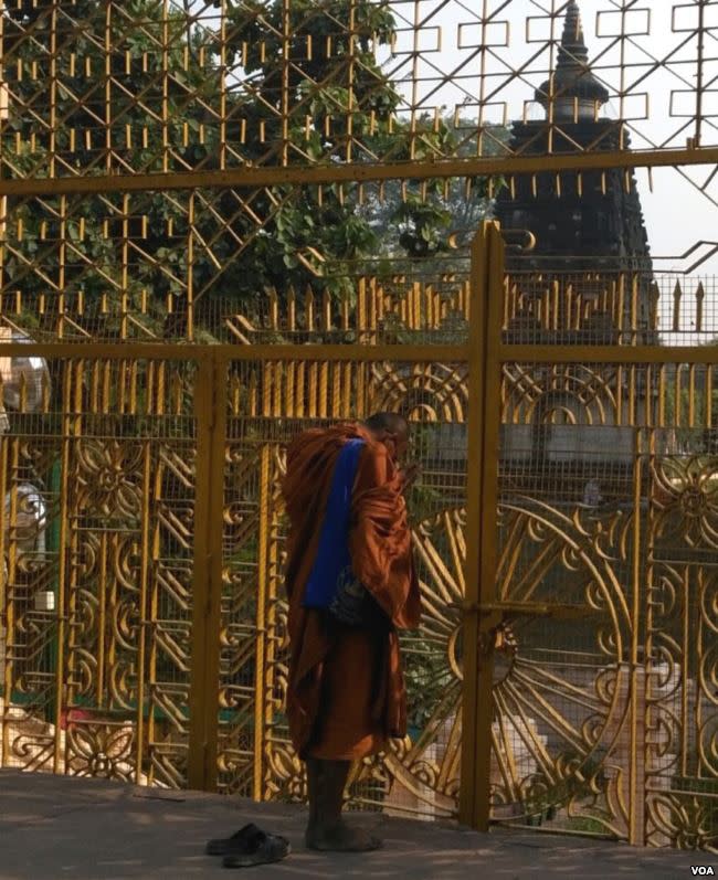 一名僧人在摩訶菩提寺外禮佛冥想。 （美國之音朱諾拍攝，2015年6月21日）