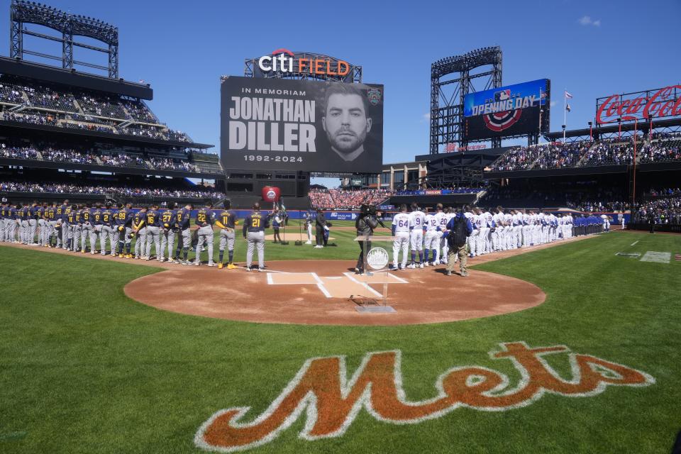 The Milwaukee Brewers and the New York Mets stand on the field during a moment of silence for New York City police officer Jonathan Diller before a baseball game Friday, March 29, 2024, in New York. Diller was shot and killed Monday during a traffic stop, the city's mayor said. (AP Photo/Frank Franklin II)