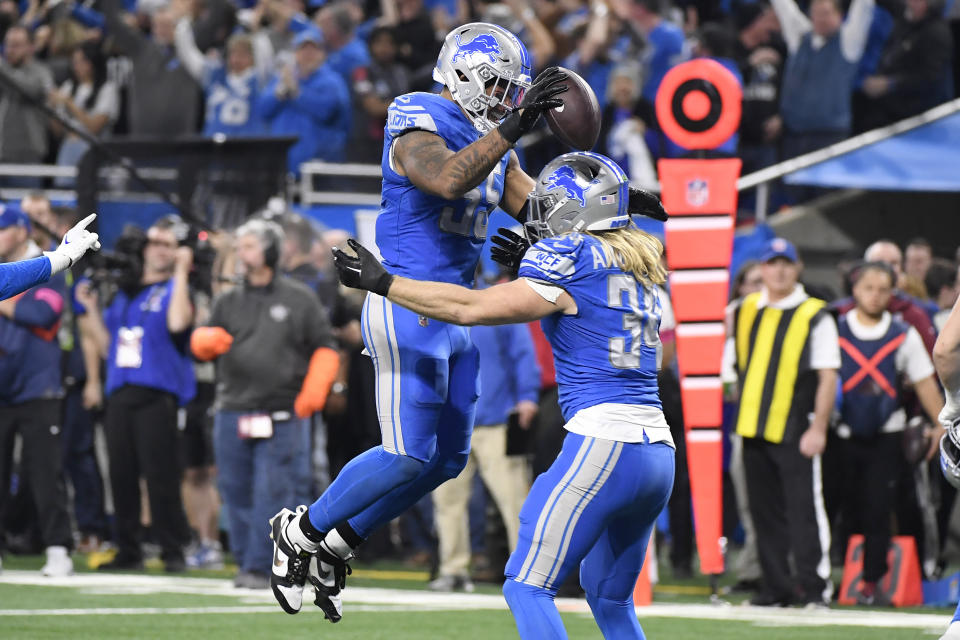 Detroit Lions linebacker Derrick Barnes, top, celebrates with Alex Anzalone (34) after intercepting a pass by Tampa Bay Buccaneers quarterback Baker Mayfield late in the second half of an NFL football NFC divisional playoff game, Sunday, Jan. 21, 2024, in Detroit. The Lions won 31-23. (AP Photo/Jose Juarez)