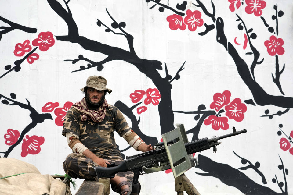 A Taliban fighter mans his weapon during celebrations one year after the Taliban seized the Afghan capital, Kabul, in front of the U.S. Embassy in Kabul, Afghanistan, Monday, Aug. 15, 2022. The Taliban marked the first-year anniversary of their takeover after the country's western-backed government fled and the Afghan military crumbled in the face of the insurgents' advance. (AP Photo/Ebrahim Noroozi)