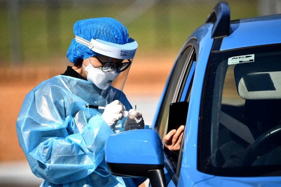 A health worker takes a swab sample at a Covid-19 coronavirus drive through testing site in the Smithfield suburb of Sydney.