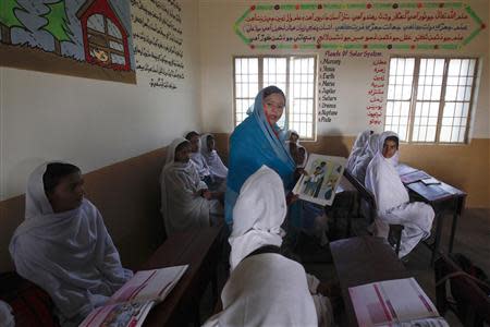 A teacher displays a flash card with an illustration depicting a student molested by a teacher, while describing measures to take when sexual harassment occurs, during a class in Shadabad Girls Elementary School in Gohram Panhwar village in Johi, some 325 km (202 miles) from Karachi February 12, 2014. REUTERS/Akhtar Soomro