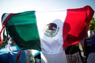 A Central American migrant holds a Mexico flag while walking along the highway near the border with Guatemala, as they continue their journey trying to reach the U.S., in Tapachula, Mexico October 21, 2018. REUTERS/Ueslei Marcelino