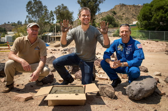 Actor Matt Damon, who stars in the film “The Martian,” smiles after making cement hand prints at the Mars Yard at the agency’s Jet Propulsion Laboratory on Aug. 18, 2015. Looking on are Mars rover Curiosity project manager Jim Erickson (left) a