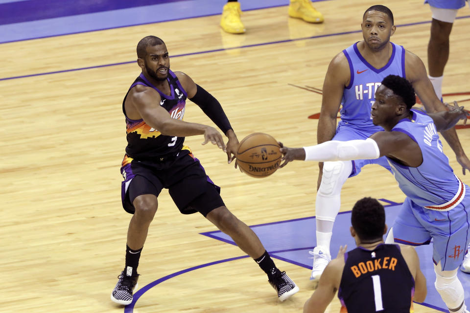 Phoenix Suns guard Chris Paul (3) attempts to pass the ball to guard Devin Booker (1), but Houston Rockets guard Victor Oladipo, right, knocks it away, while Rockets guard Eric Gordon, back, watches during the first half of an NBA basketball game Wednesday, Jan. 20, 2021, in Houston. (AP Photo/Michael Wyke)