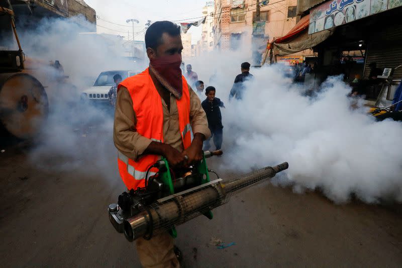 FILE PHOTO: Worker sprays fumigation vapour to stem the spread of Dengue virus in Karachi