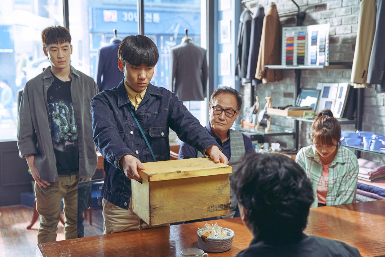 As Move To Heaven trauma cleaners, Geu-ru (Tang Jun-sang) and Sang-gu (Lee Je-hoon) clean up the belongings of the deceased and place them into yellow boxes. (Photo: Netflix)