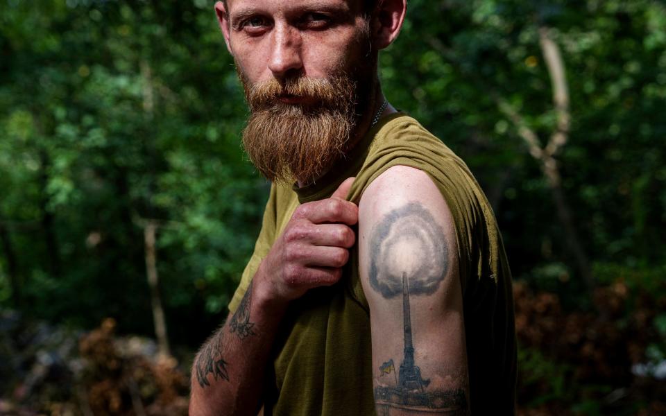 Anton, a Ukrainian artilleryman, shows his howitzer tattoo