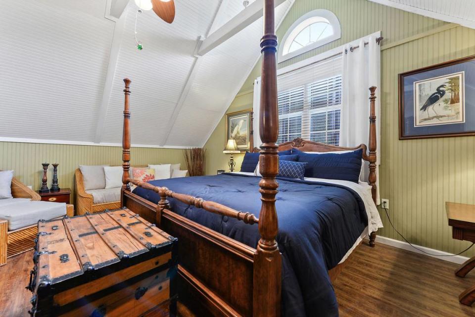 An upstairs bedroom with gabled ceiling at Breezy Porches, a unique log-sided home on Nicholson Avenue in Waveland. MS Real Estate Photography