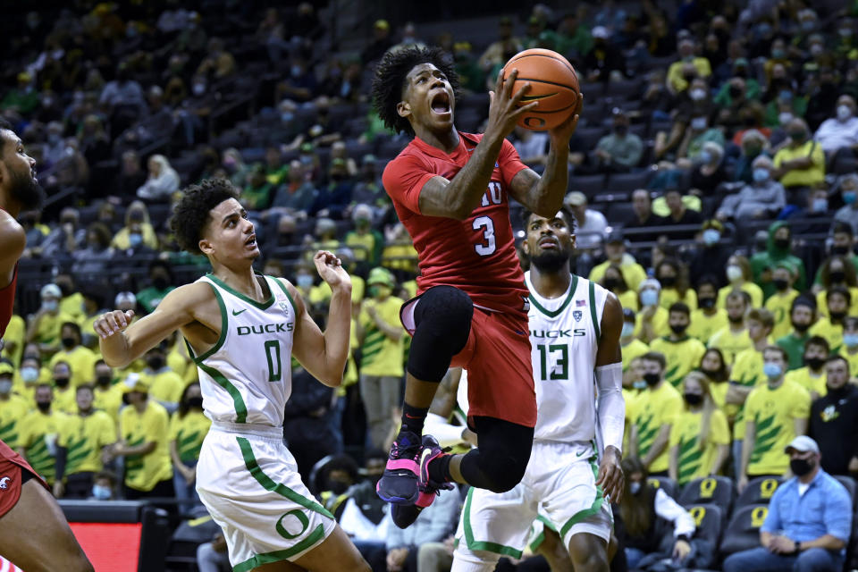 FILE -SMU guard Kendric Davis (3) drives past Oregon guard Will Richardson (0) and forward Quincy Guerrier (13) during the second half of an NCAA college basketball game Friday, Nov. 12, 2021, in Eugene, Ore. Kendric Davis will try to defend his American Athletic Conference player of the year title at a different school. The 6-footer led the AAC with 19.4 points per game at SMU and also ranked third in the league in assists (4.4) at SMU last season. (AP Photo/Andy Nelson, File)