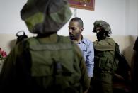 In this photo taken April 17, 2014 released by the Warren Film, American director James Adolphus directs actors dressed in Israeli army uniforms at the filming location of his movie in the West Bank city of Nablus. The American director's short film about an Israeli army raid in a Palestinian refugee camp ends with a surprise _ literally involving a rabbit, though not one pulled from a hat. The story told in “The Warren” is meant to question preconceptions Israelis and Palestinians hold about each other in their long-running conflict. (AP Photo/The Warren Film)