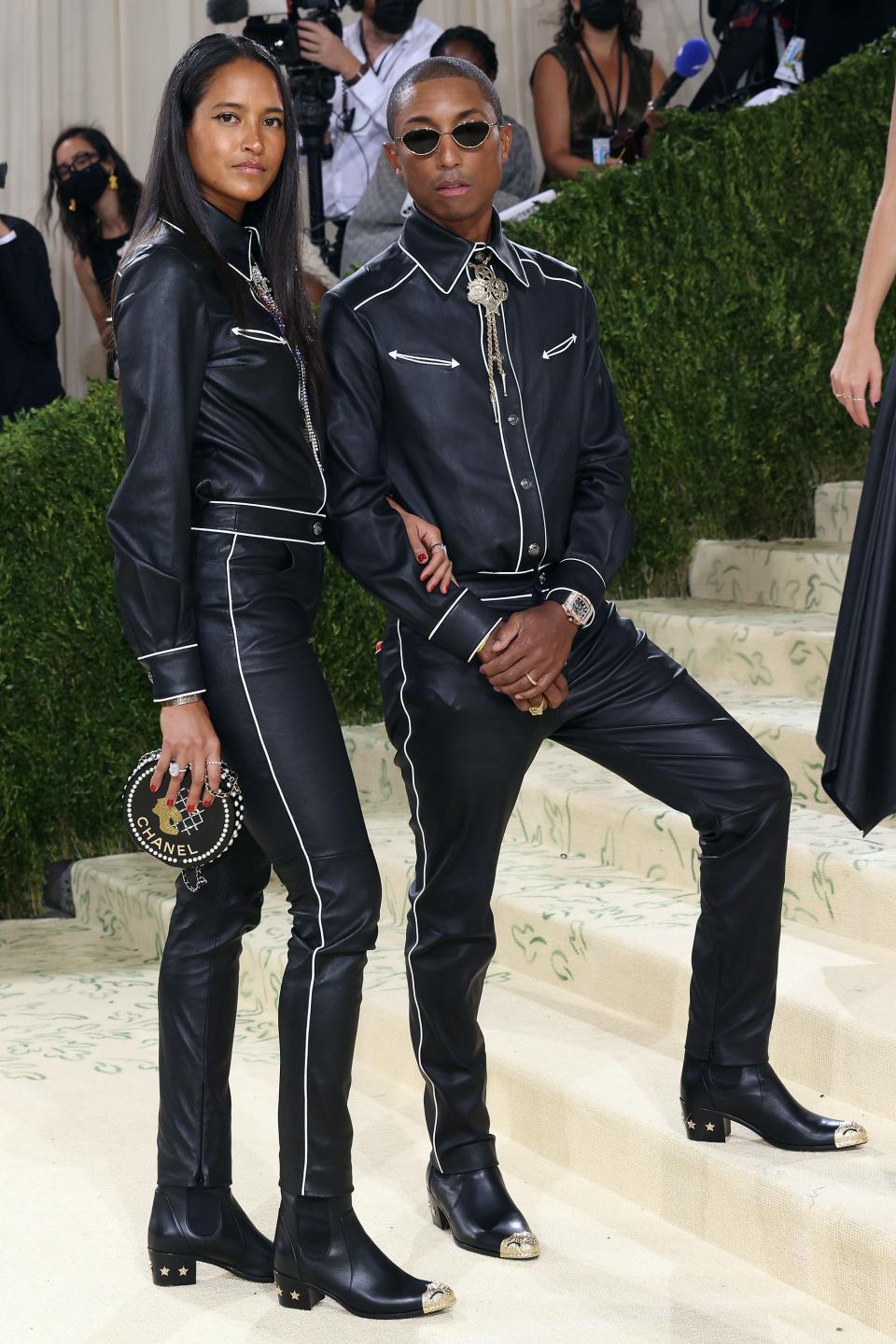 Helen Lasichanh standing taller than Pharrell Williams both in the same black leather western ensemble and short heels.