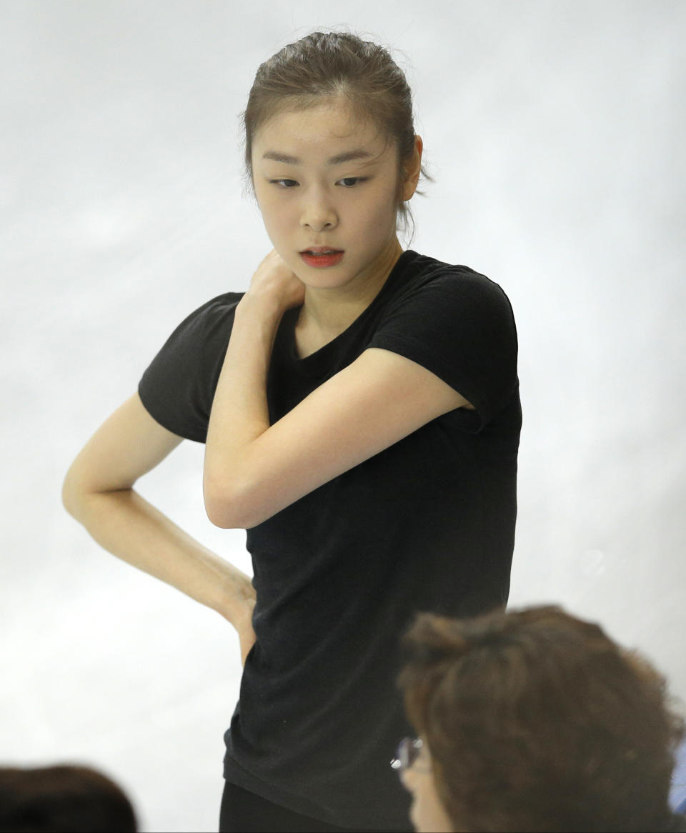 Figure skater Yuna Kim of South Korea speaks with team members in the practice rink at the 2014 Winter Olympics, Thursday, Feb. 13, 2014, in Sochi, Russia. (AP Photo/Vadim Ghirda)