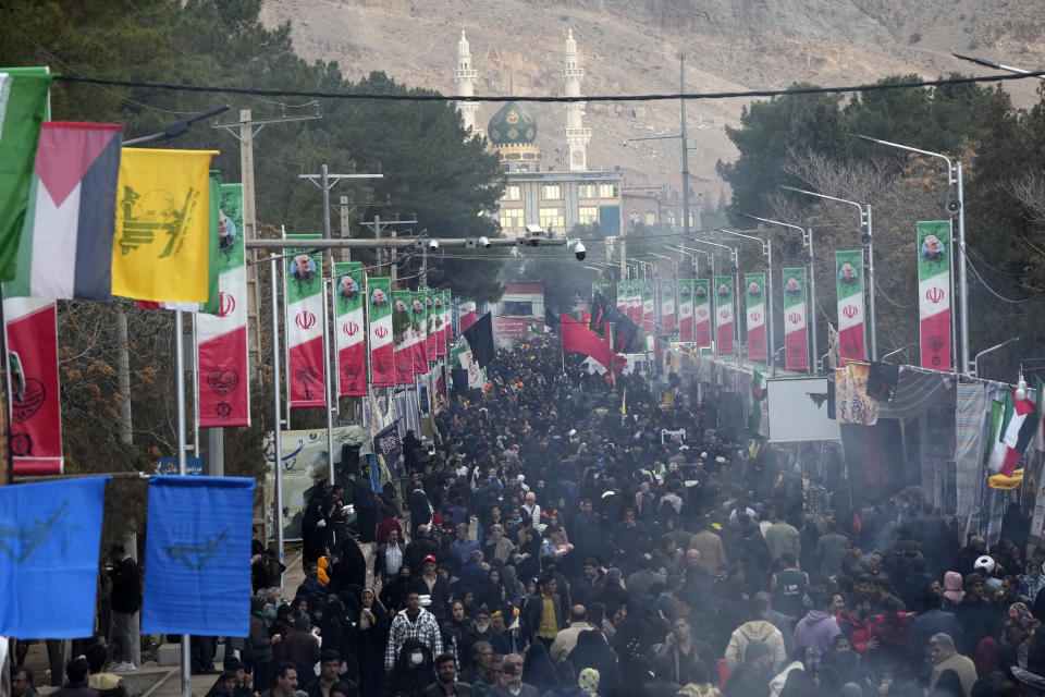 People walk on the street towards the grave of the late Iranian Revolutionary Guard Gen. Qassem Soleimani as a mosque is seen in background in the city of Kerman about 510 miles (820 kms) southeast of the capital Tehran, Iran, Thursday, Jan. 4, 2024. Investigators believe suicide bombers likely carried out an attack on a commemoration for an Iranian general slain in a 2020 U.S. drone strike, state media reported Thursday, as Iran grappled with its worst mass-casualty attack in decades and as the wider Mideast remains on edge. (AP Photo/Vahid Salemi)