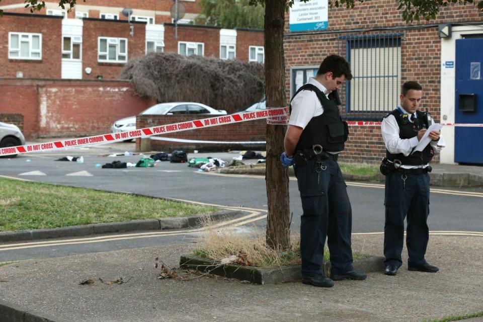 Police guard the scene following the stabbings (PA)