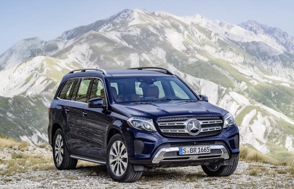 A dark blue Mercedes-Benz GLS, a large luxury crossover SUV, with mountains in the background.