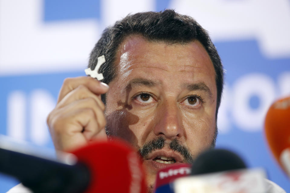 Italian Interior Minister and Deputy Premier Matteo Salvini, of the League, holds a crucifix as he talks to reporters during a press conference at the League headquarters in Milan, Italy, early Monday morning, May 27, 2019. (AP Photo/Antonio Calanni)