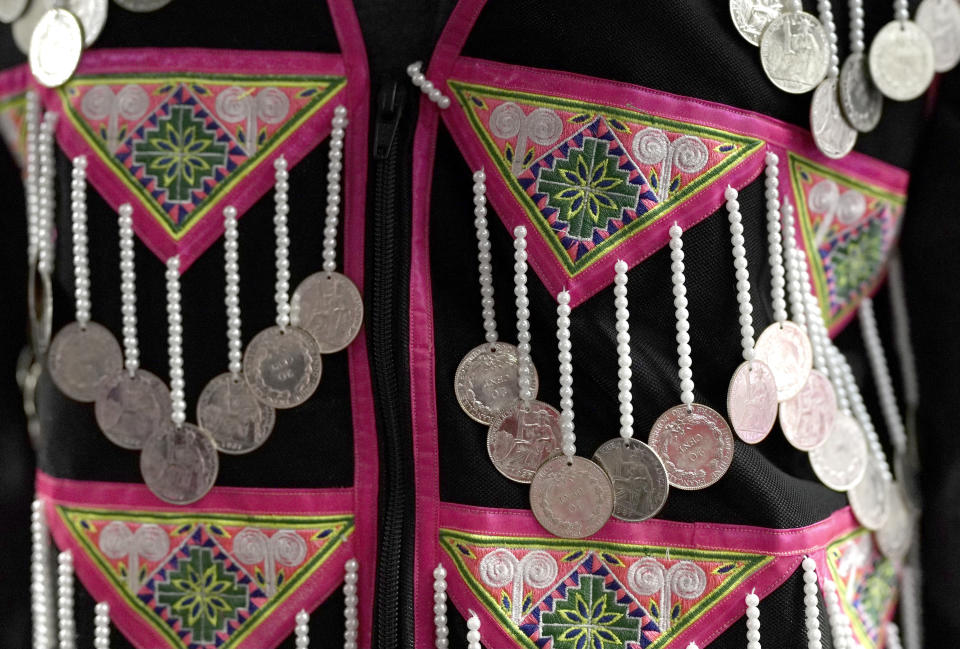 Traditional embroidered vests with jewelry are seen for sale in the Hmong Village covered market in St. Paul, Minn., on Thursday, Nov. 16, 2023. For the New Year celebrations held in the fall, the Hmong, Southeast Asian refugees who settled in the United States after fighting on its side in the Vietnam War, traditionally buy or make new clothes and gather for spiritual ceremonies. (AP Photo/Mark Vancleave)