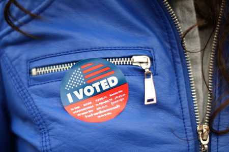 A woman wears a sticker in multiple languages after voting in the primary election at a polling station in Venice, Los Angeles, California, U.S. June 5, 2018. REUTERS/Lucy Nicholson