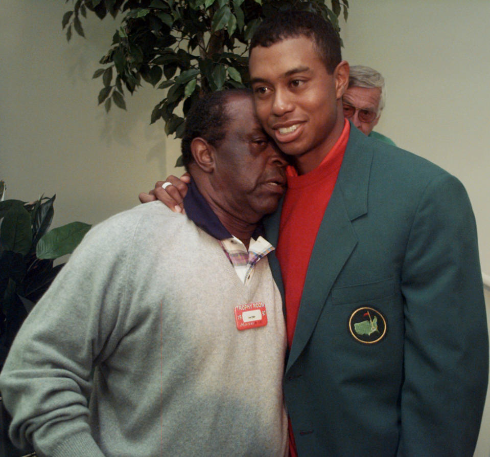 FILE - Masters champion Tiger Woods, right, gets a hug from Lee Elder after the final round of Masters play at the Augusta National Golf Club in Augusta, Ga., Sunday, April 13, 1997. Hank Aaron made history with one swing of his bat. A year later and on the other side of Georgia, Elder made history with one swing of his driver. Their deaths in 2021 were mourned beyond the sports world and were reminders of the hate, hardships and obstacles they endured with dignity on their way to breaking records and barriers. (AP Photo/Amy Sancetta, File)