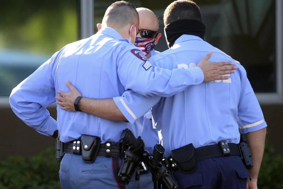 Police officers in McAllen, Texas console each other after two colleagues were shot dead (The Monitor via AP)