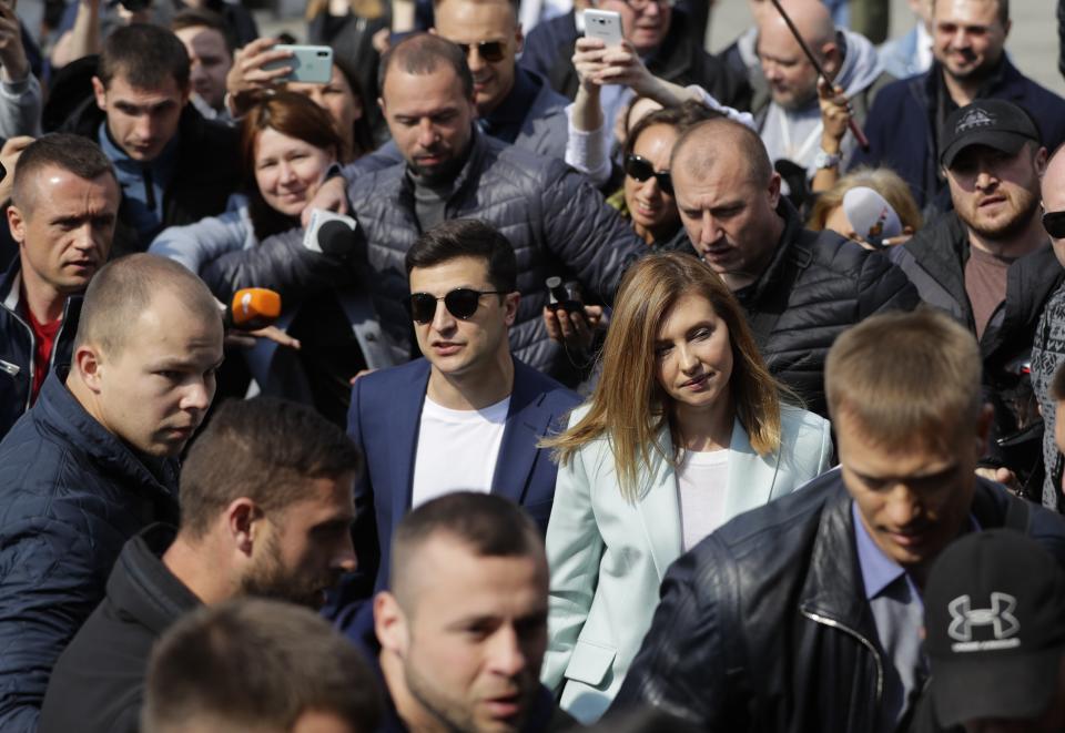 Ukrainian comedian and presidential candidate Volodymyr Zelenskiy, center left, and his Olena Zelenska, second right, arrive at a polling station, during the second round of presidential elections in Kiev, Ukraine, Sunday, April 21, 2019. Top issues in the election have been corruption, the economy and how to end the conflict with Russia-backed rebels in eastern Ukraine. (AP Photo/Sergei Grits)