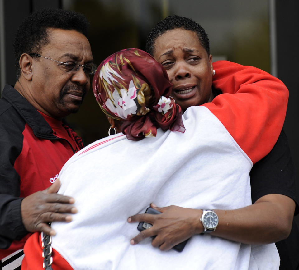 Employees hug in front of the UAW Local 7 hall across the street from Chrysler Jefferson North Assembly plant in Detroit on Thursday, Sept. 20, 2012 after a factory employee fatally stabbed his co-worker at Chrysler Group LLC's Jefferson North Assembly Plant. Detroit police Inspector Dwane Blackmon says the suspect fled the Jefferson North plant Thursday morning and shot himself to death at nearby Belle Isle Park. (AP Photo/Detroit News, David Coates) DETROIT FREE PRESS OUT; HUFFINGTON POST OUT. MANDATORY CREDIT
