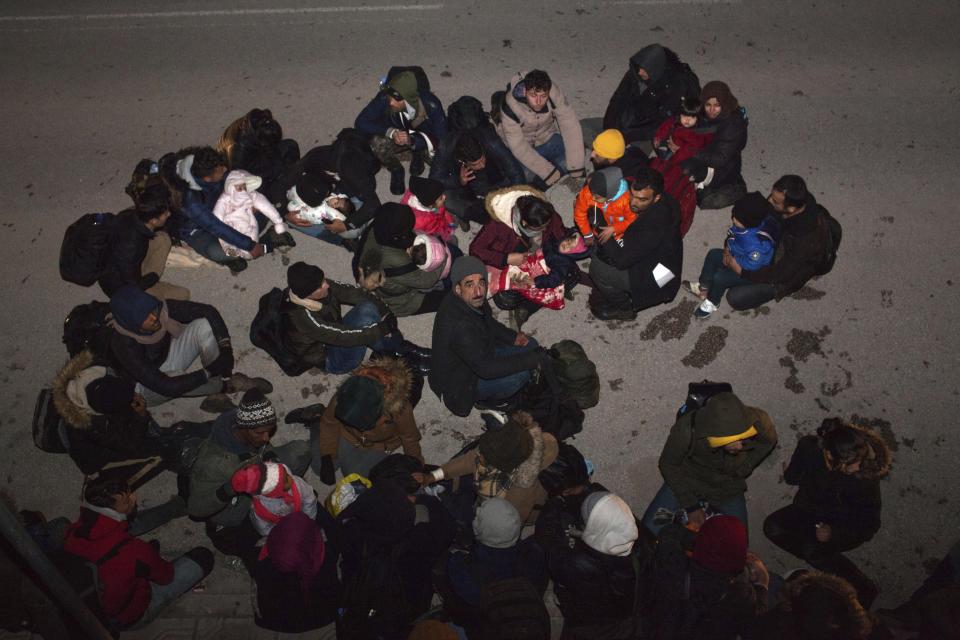 Migrants from Syria and Iraq wanting to register for asylum, sit on the road in Orestiada town, northeastern Greece, Monday, April 22, 2019. Greek authorities say dozens of asylum-seekers have turned up at the front door of European border agency employees helping police Greece's northeastern border with Turkey. (AP Photo/Antonis Pasvantis)