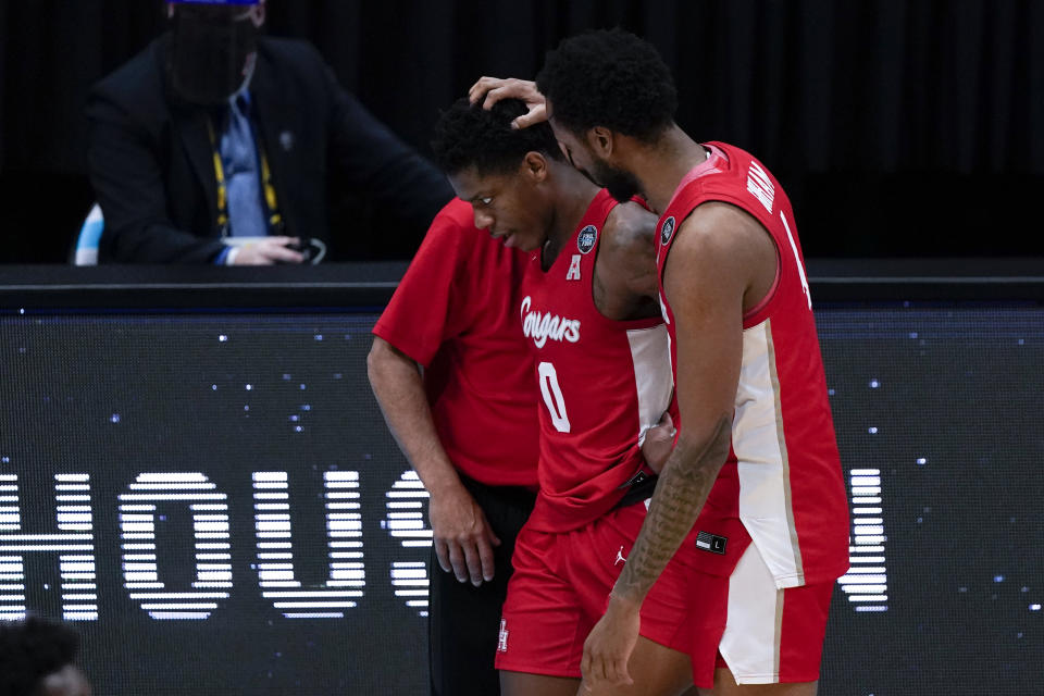 Houston guard Marcus Sasser (0) walks off the court with teammate forward Justin Gorham, right, at the end of a men's Final Four NCAA college basketball tournament semifinal game against Baylor, Saturday, April 3, 2021, at Lucas Oil Stadium in Indianapolis. Baylor won 78-59. (AP Photo/Michael Conroy)