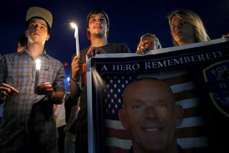 Mourners attend a candlelight vigil for slain Fox Lake Police Lieutenant Charles Joseph Gliniewicz in Fox Lake, Illinois, United States, September 2, 2015. REUTERS/Jim Young