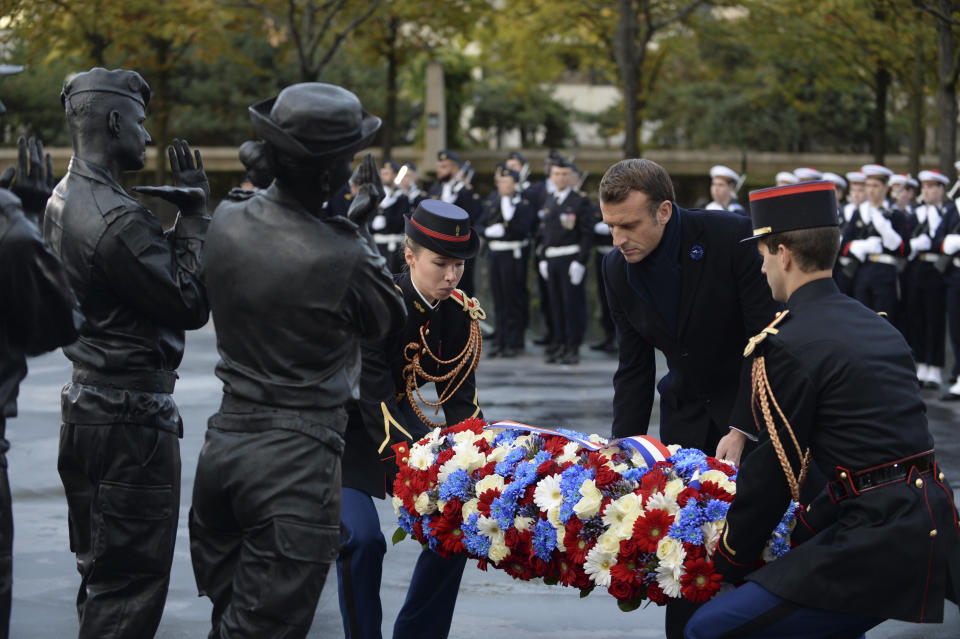 French President Emmanuel Macron lays a wreath of flowers as he inaugurates a memorial for soldiers fallen in foreign conflicts, Monday Nov. 11, 2019 in Paris. As part of commemorations marking 101 years since World War I's Armistice, French President Emmanuel Macron led a ceremony for the 549 French soldiers who died in 17 theaters of conflict since the 60s. The monument memorial depicts six soldiers _ five men and a woman _ holding up an invisible coffin. (Johanna Geron/Pool via AP)