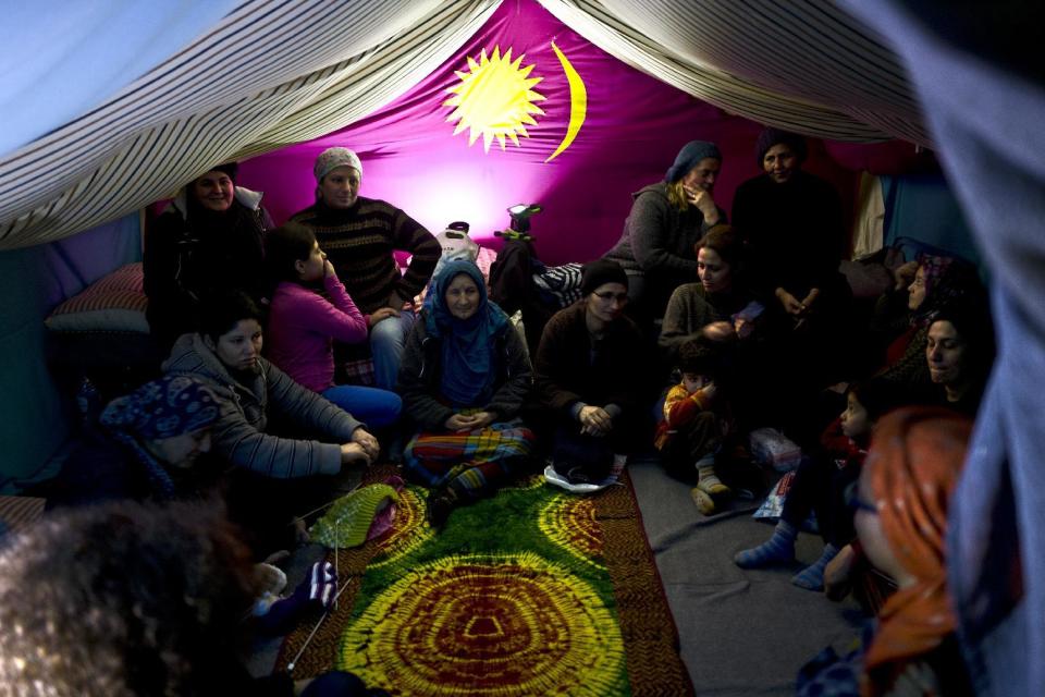 In this Wednesday, Jan. 18, 2017 photo, Syrian refugee women attend a knitting class part of emotional support session provided to them by volunteers from the Refugee Trauma Initiative, in a tent in Frakapor refugee camp on the outskirts of the northern Greek city of Thessaloniki. Many migrants living in this warehouse tent camp and another one nearby are feeling burned out. They try to keep busy as they dream of a better life in Western Europe and not let boredom or depression set in. (AP Photo/Muhammed Muheisen)