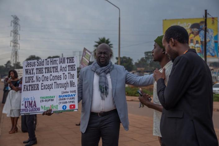 A man blessing two passers-by