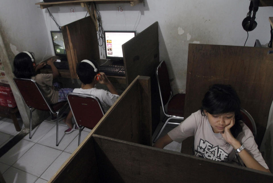 In this Friday, Oct. 19, 2012 photo, Indonesian youths browse at an internet cafe in Jakarta, Indonesia. There are growing numbers of incidents involving internet social media networks being used as a mean for children trafficking in Indonesia, at least eight reported this month alone of young girls being abducted and enslaved by men who approached them randomly on Facebook, raising concerns that the overall number of trafficked children remains grossly underestimated in the sprawling archipelago of 240 million. (AP Photo/Tatan Syuflana)