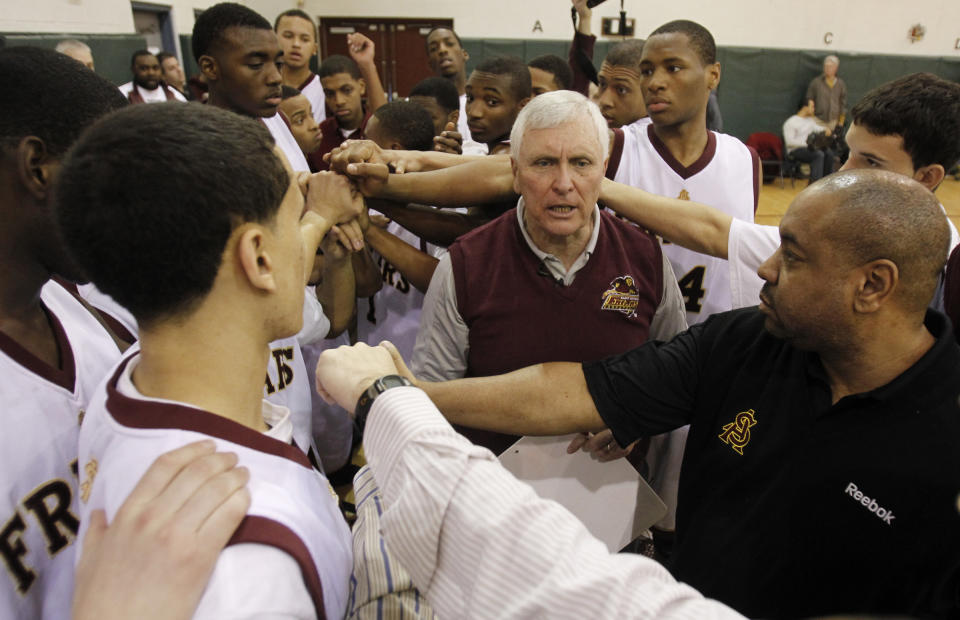 FILe - In this Feb. 2, 2011, file photo, Bob Hurley, center, head coach of the St. Anthony High School boys' basketball team, huddles with his team during a game against St. Mary's, in Jersey City, N.J. St. Anthony won the game, 76-46, giving Hurley his 1,000 career coaching victory. In a half century at St. Anthony's, Hall of Fame basketball coach Bob Hurley has won on an almost unparalleled level in high school. But now the school that has been a haven to the poor seeking a Roman Catholic education could soon be closing its doors. (AP Photo/Julio Cortez, File)