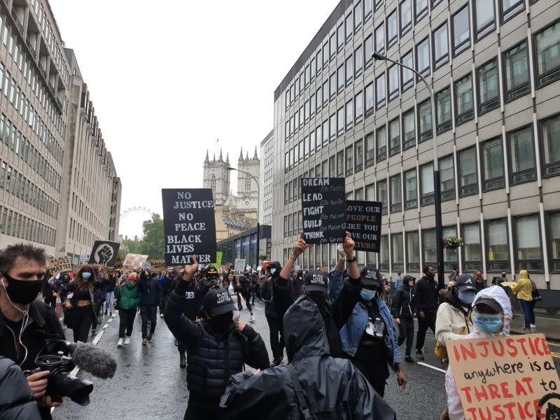 Demonstrators hold signs during a Black Lives Matter protest in Parliament Square, following the death of George Floyd who died in police custody in Minneapolis, in London