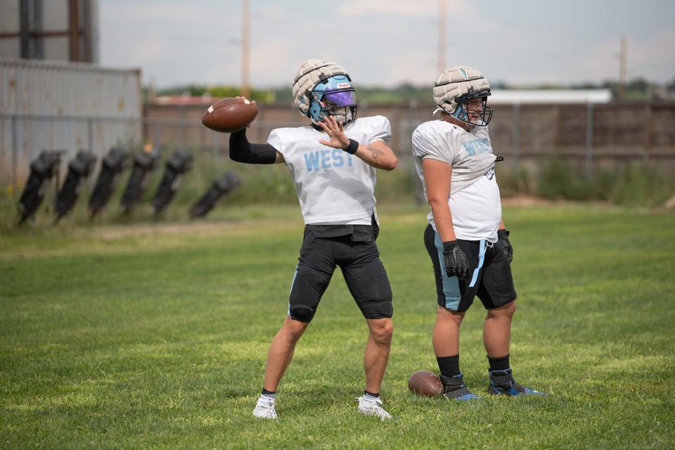 Pueblo West's Gavin Lockett, left, pulls back to pass during football practice on Thursday, August 10, 2023.