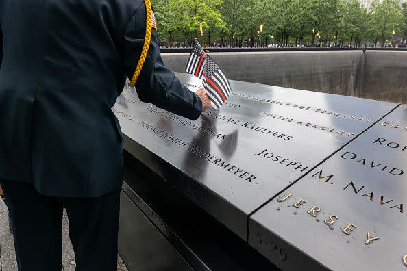 NEW YORK, NEW YORK - SEPTEMBER 11: Retired police officer Sam Pulia places flags on the names along the 9/11 Memorial at the Ground Zero site in lower Manhattan as the nation commemorates the 22nd anniversary of the attacks on September 11, 2023 in New York City. Monday marks the 22nd anniversary of the September 11 terrorist attacks on the World Trade Center and the Pentagon, as well as the crash of United Airlines Flight 93. In total, the attacks killed nearly 3,000 people and commenced a global war on terror which included American led conflicts in both Iraq and Afghanistan.   (Photo by Spencer Platt/Getty Images)