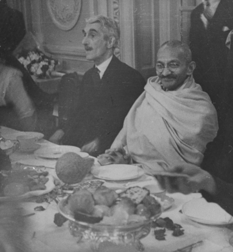 Mahatma Gandhi (r), wearing cloth wrapped around shoulders, sitting at banquet w. unident. man. (Photo by Aral/Pix Inc./The LIFE Images Collection via Getty Images/Getty Images)